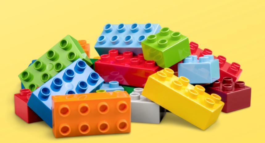 A pile of multicolored Legos against a yellow background